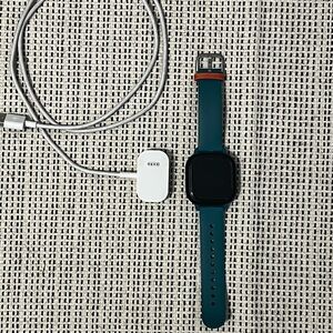 Smartwatch with Teal Strap and Charging Cable